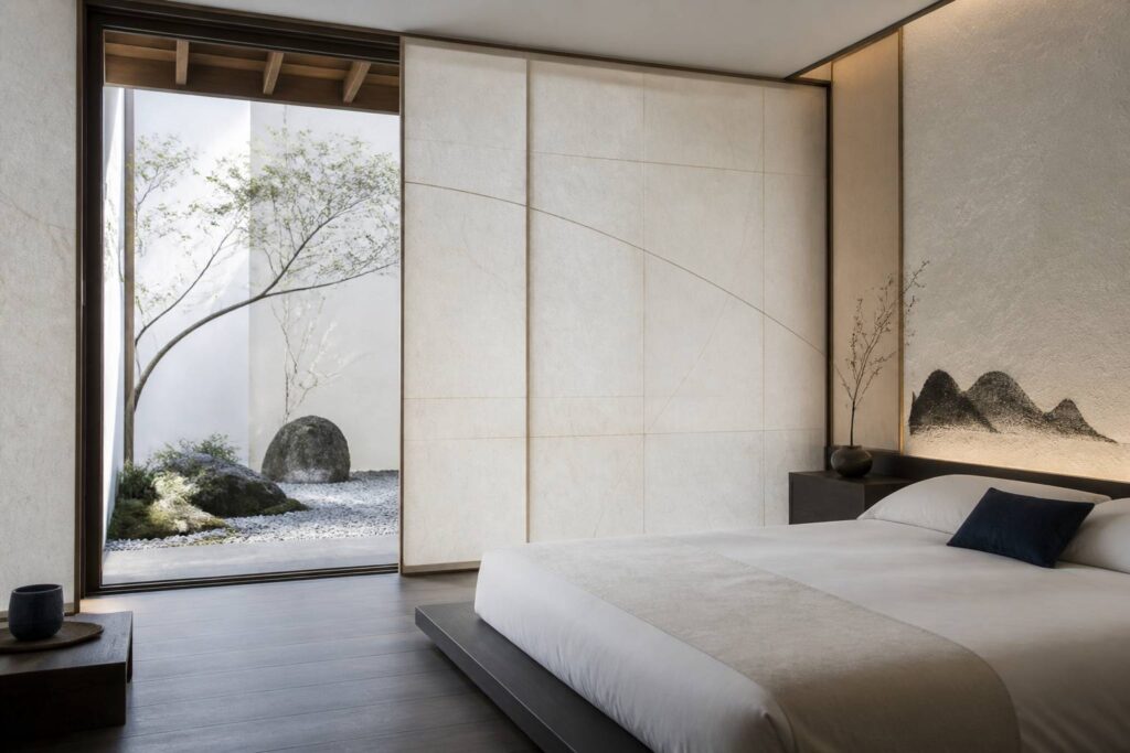 Chambre d'hôtel japonaise épurée avec lit bas et lumière douce