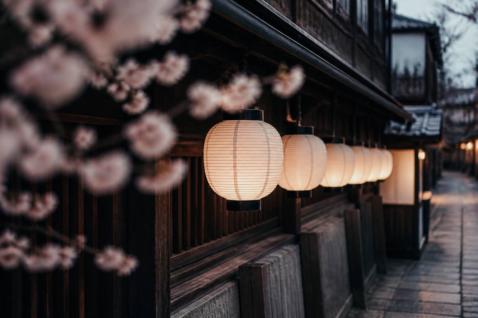 Lanternes en papier sous une maison traditionnelle en bois de Kyoto