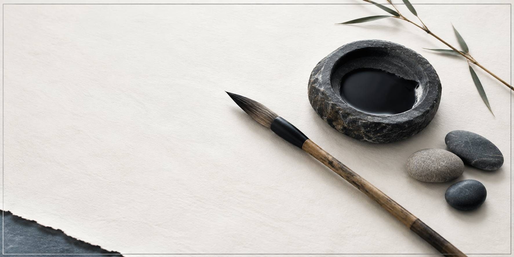 Gros plan d'un pinceau de calligraphie et d'une pierre a encre sur papier vierge